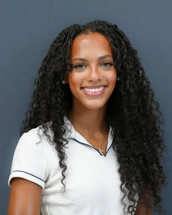 Studio headshot, female subject, white polo