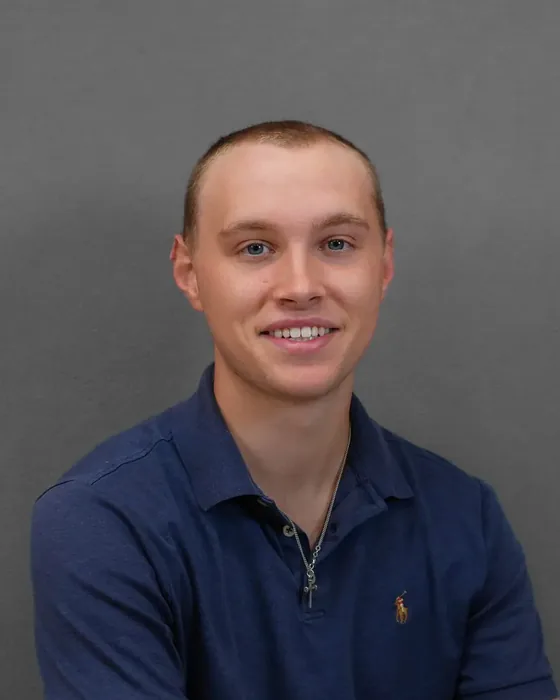 Studio headshot, male subject, navy polo
