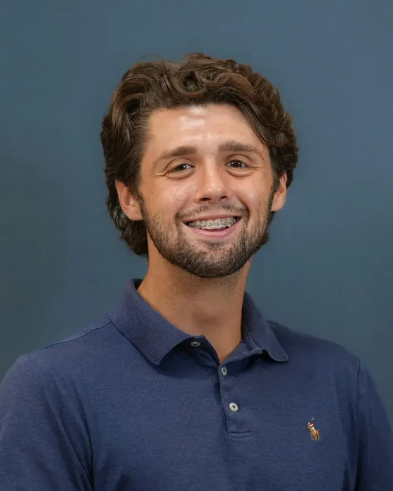 Studio headshot, male subject, navy polo