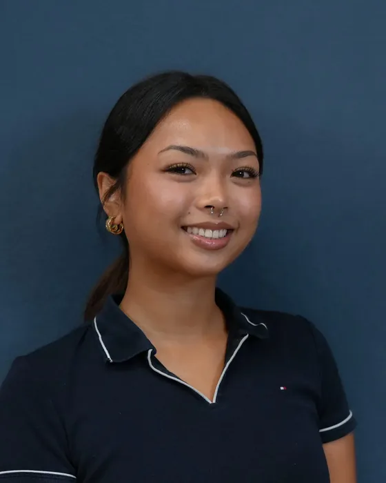 Studio headshot, female subject, navy polo