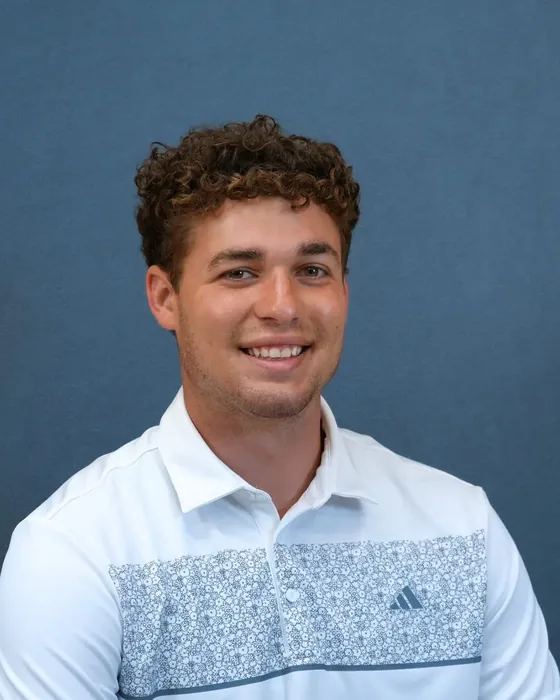Studio headshot, male subject, white polo