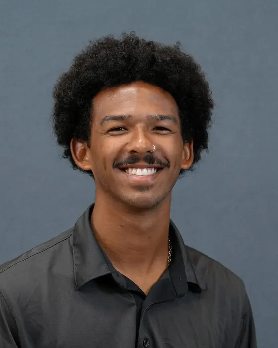 Studio headshot, male subject, dark shirt